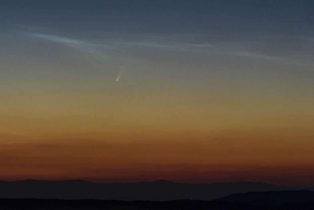 The comet NEOWISE shoots across the sky at dusk above northeastern Hungary